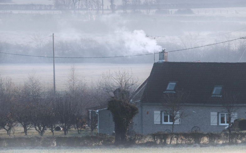 Kaldt hus på jorde med røyk fra pipe og frostrøyk på bakken
